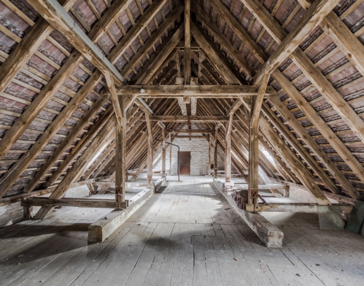 Attic under renovation with skylights, dust barriers, and protective coverings to minimise disruption.