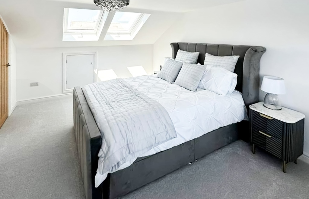 Elegant Irish attic lounge with bespoke carpentry, natural light, and warm-toned furnishings.