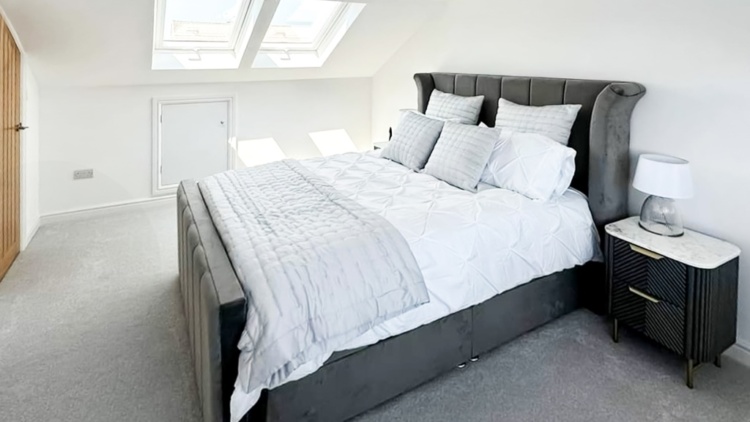 Elegant Irish attic lounge with bespoke carpentry, natural light, and warm-toned furnishings.