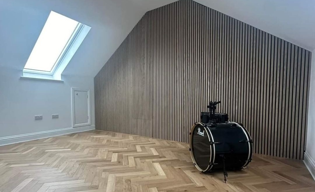 Modern attic with parquet flooring and slatted feature wall, showcasing design-focused renovation support from The Irish Attic Company.