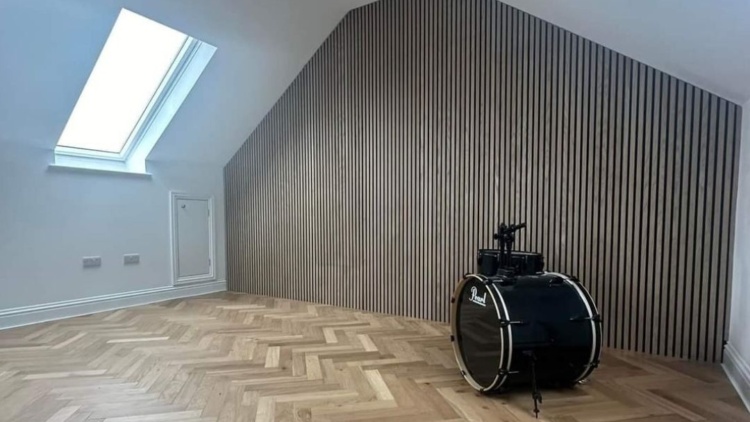 Modern attic with parquet flooring and slatted feature wall, showcasing design-focused renovation support from The Irish Attic Company.